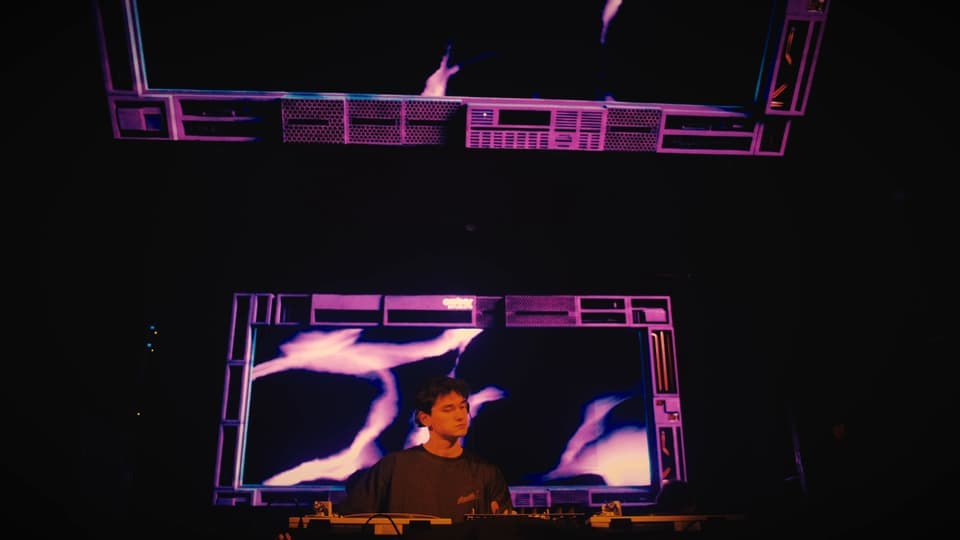 La cabina bajo las pantallas, con el dibujo blanco y violeta, en Crobar House Music Weekend