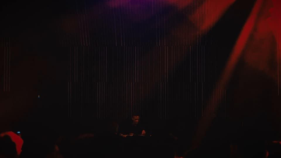 La sala casi a oscuras, con un haz rojo cruzándola, en Crobar House Music Weekend