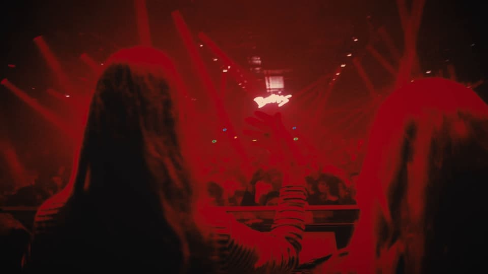 La cabina bajo la luz roja, entre el público, en The Bow